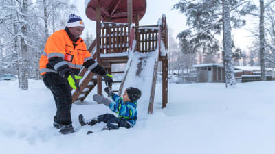 Lamin leikkii lapsensa kanssa lumessa.