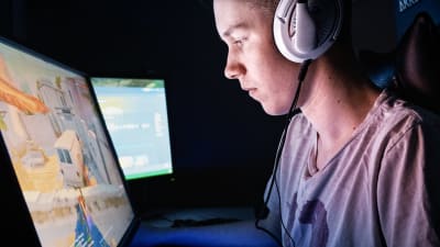 E-urheilija Verneri "Bona" Junkala pelaa näyttöruutujen äärellä CS:GO-tietokonepeliä.