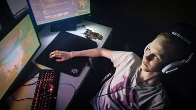 E-urheilija Verneri "Bona" Junkala pelaa tietokoneruutujen äärellä CS:GO-videopeliä.