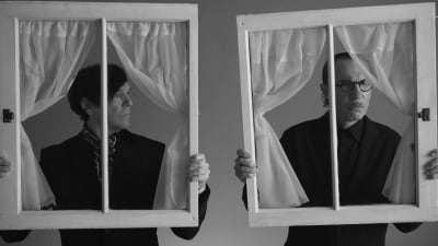 Ron ja Russell Mael eli popduo Sparks poseeraa mustavalkoisessa kuvassa ikkunankarmit kädessä. Kuva dokumenttielokuvasta The Sparks Brothers.