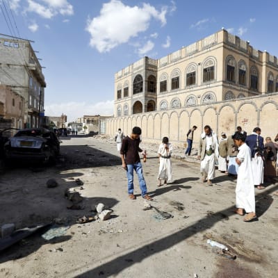 Människor inspekterar platsen i Sanaa där brutala självmordsattacker inträffade den 20 mars 2015.