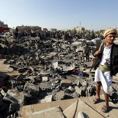 Huthirebell står vakt på ett område i Sanaa där Saudiarabien har utfört flygattacker.