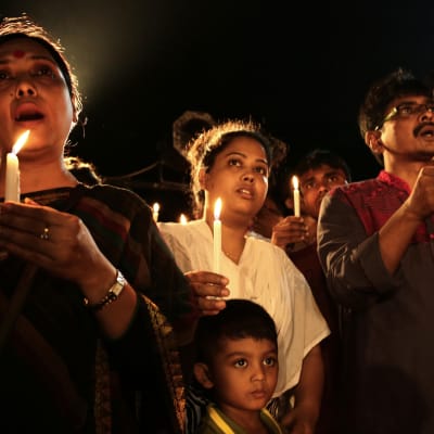 Människor hedrar offren i terrorattacken mot en restaurang i Dhaka.