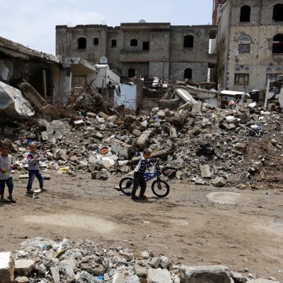 Förstörda hus och barn som promenerar bland husras. Barn promenerar i Sanaa den 3 augusti bland förstörda hus efter luftanfall från den saudiledda koalitionen