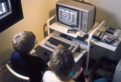 Två pojkar spelar på en Commodore 64, 1986