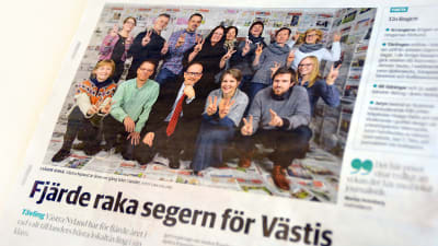 En bild av en tidningssida där en mängd människor ser glada ut. I rubriken till artikeln står det "Fjärde raka segern för Västis".