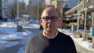 En skallig man i svart tröja.