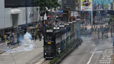 Kravallpoliser i Hongkong använde tårgas för att skingra tusentals demonstranter i stadskärnan. 