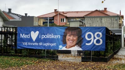 Valbanderoll för Moderaterna på Åland, intill höstlig torgpark i Mariehmn