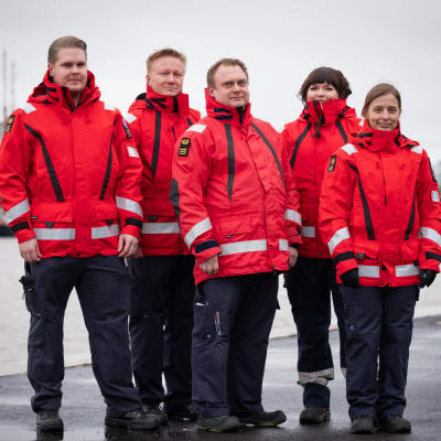 Åbo Sjöräddningssällskap vid Aura å, klädda i röda sjöräddnings-jackor. 