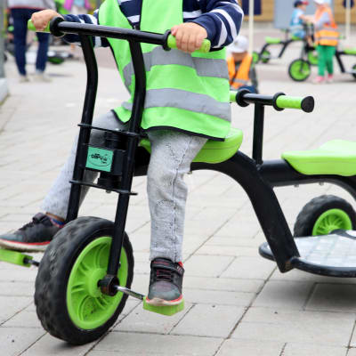 Ett barn trampar på en trehjuling.