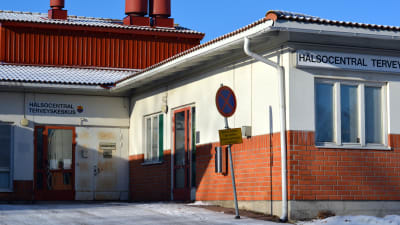 Bild på Ingå hälsostation utifrån. Ett vitt och tegelrött hus.