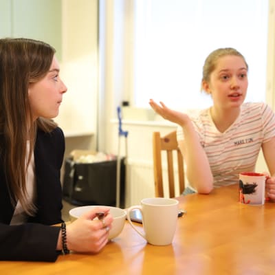 Sofia Kochetkova ja Lidiia Malova istuvat teekuppien ja murokulhojen kanssa Sallan lukion asuntolan keittiössä. 
