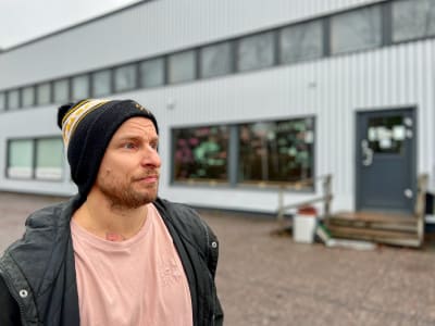 Joni Rönneberg utomhus framför byggnad. 