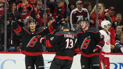 Sebastian Aho firar ett mål med armarna upp i luften tillsammans med lagkamrater.