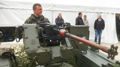 En polsk soldat tittar närmare på den estniska obemannade Milrem-bandvagnen som här är utrustad med en kulspruta.