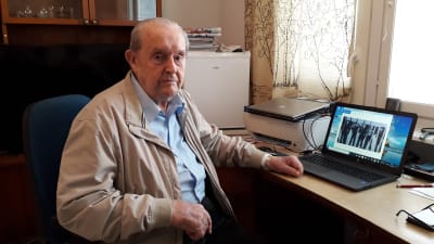 99-åriga Ragnar Nordström sitter vid skrivbordet med datorn öppen.