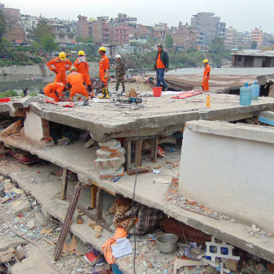 Räddningsarbetare letar efter överlevande i ett rasat flervåningshus.