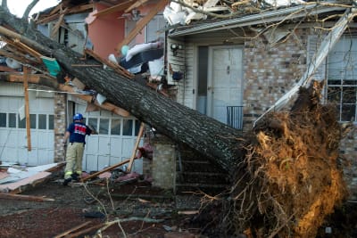 En brandman granskar hem i området Walnut Ridge efter att en tornado skadat hundratals hem och byggnader.