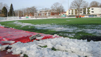 En fotbollsplan täckt av is och snö.