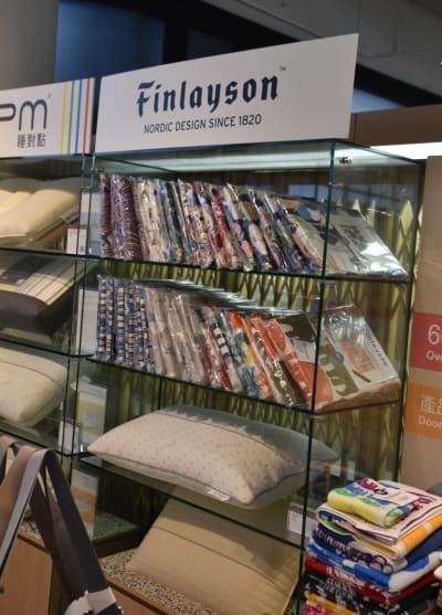 Butikshylla med färglada Finlayson-textilier.