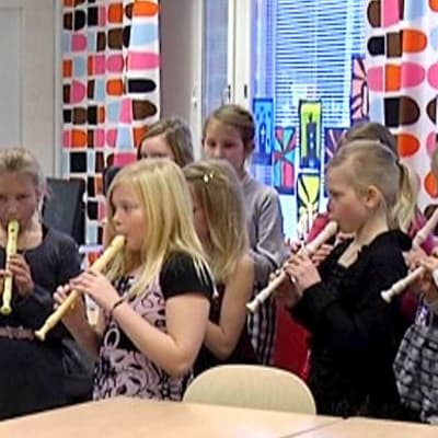 Kuvassa nokkahuilua soittavia koululaisia uudessa luokassa.
