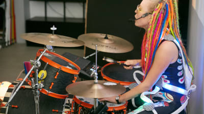Vegas sommarpratare Vicky O'Neon eller Vicky Österberg i prfil spelar trummor med headsset för sång och färggranna dreadlocks.