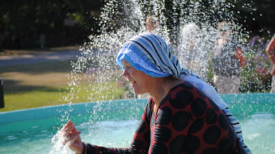 Mia Maukonen plaskar med vattnet i fontänen.