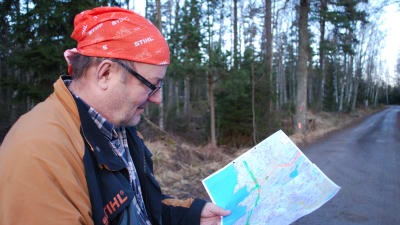 Skogsföretagaren Pekka Riekko tittar på en karta.