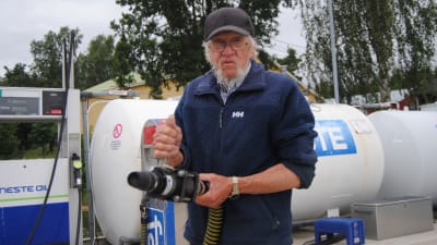 Göran Wikström vid Sommaröstrand håller i sugslangen för tömning av septiktank i båt.