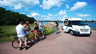 Forografen justerar en mikrofon i samband med att vi filmar cykling på Åland till En svensk sommar i Finland.