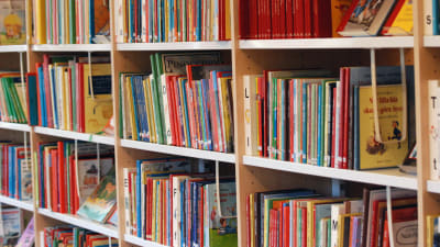 Barnböcker i en bokhylla på ett bibliotek.
