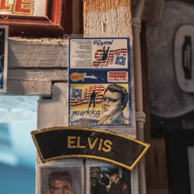 En papperslapp med bild på artisten Elvis Presley och texten "Elvis-purkka" fasthäftad på en dörrpost.