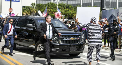 En Trumpmotståndare ställer sig framför Trumps bil när han den förre presidenten lämnar den federala domstolen i Miami.