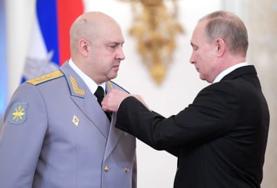 Presidentti Vladimir Putin kiinnittää kunniamerkkiä Sergei Surovikinin univormuun.
