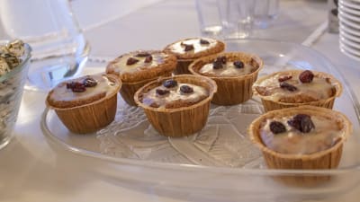 Sju muffinsliknande bakelser ligger på ett serveringsfat på ett bord.