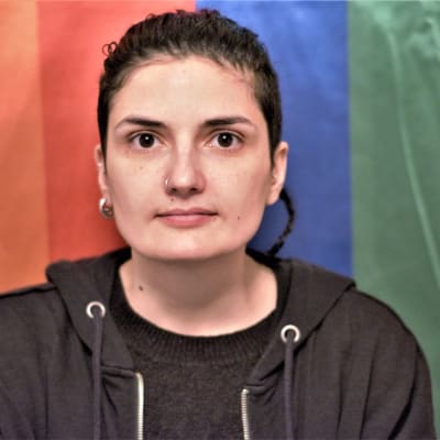 Den albanska hbtq-aktivisten Xheni Karaj framför prideflagga