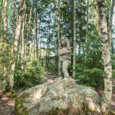 Staty på sten i skogen.