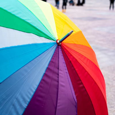 Paraply i regnbågens färger.