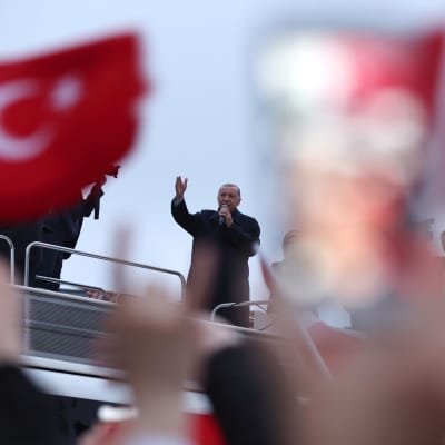 Erdogan talar till folket som viftar med Turkiets flaggor.