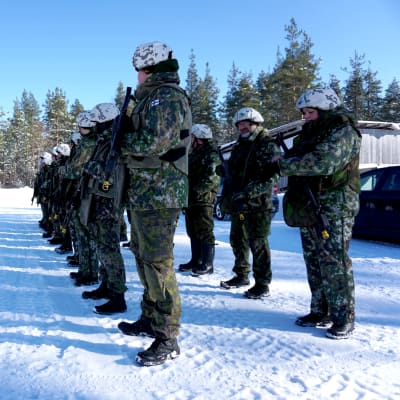 Personer i militäruniform står i formation.
