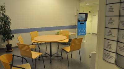 Ett tomt bord med stolar runt i en korridor.