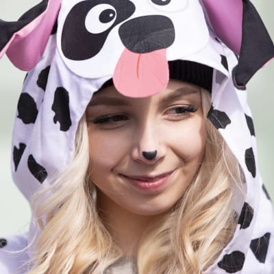 Dalmatialaisasuun pukeutunut nuori naisabi hymyilee lähikuvassa.