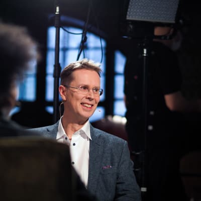 Nicklas Wancke hymyilee ja katsoo kameran ohi oikealle. Etualalla Sean Ricksin hiukset.