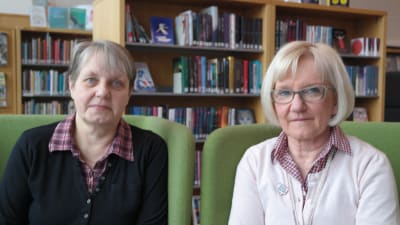 Gunilla Ritkaew och Anne Lindroos sitter i gröna fåtöljer i biblioteket i Villa Lande i Kimito