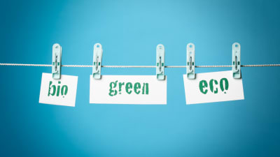 Lappar med texten bio, green och eco hänger på ett klädstreck.