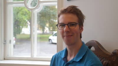 Teologiestuderande Alexander Nykvist sitter vid ett fönster