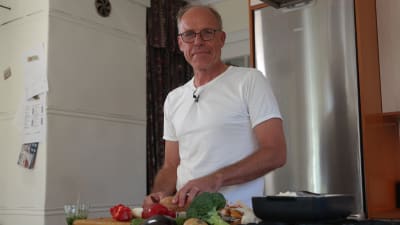 Kocken Paul Reuter skär grönsaker i sitt kök