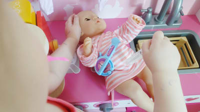 Barnet leker att hon ger spruta åt en docka.