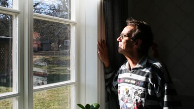 Björn Skifs tittar ut genom sitt fönster i den gamla prästgården där han bor.